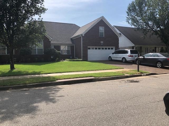 a view of a house with a yard and sitting area