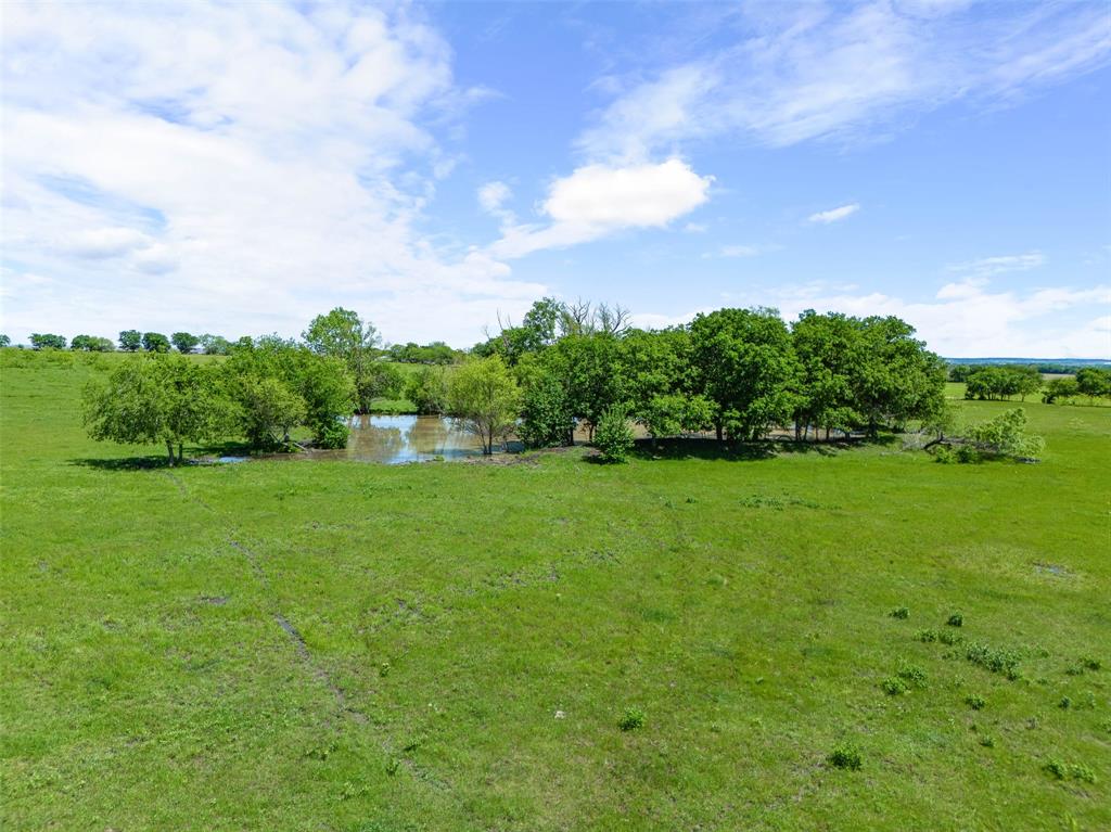 a view of a green field with wooden fence