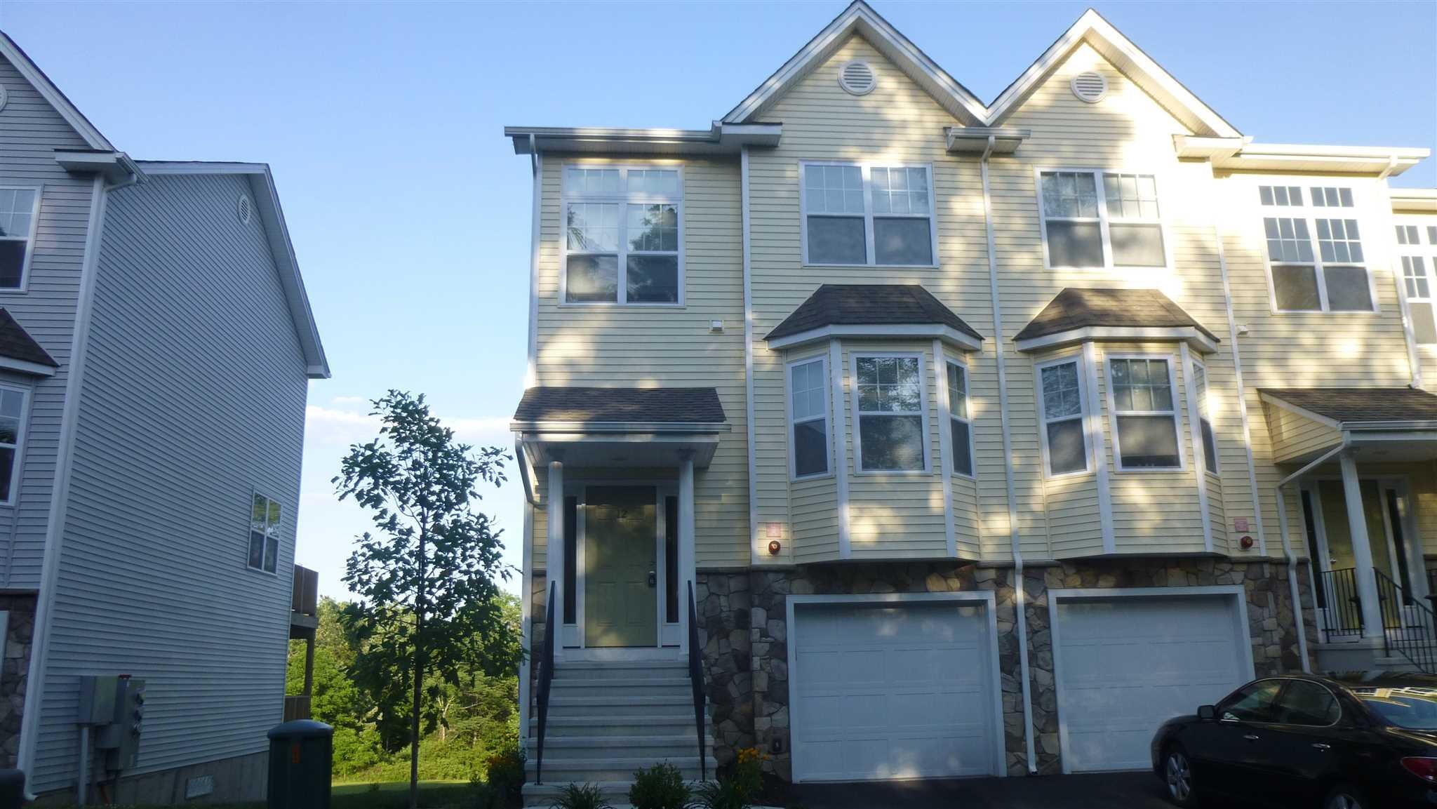 a front view of a house with yard garage and fountain