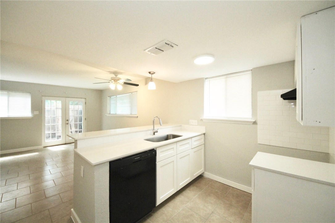 a view of a sink and dishwasher with wooden floor