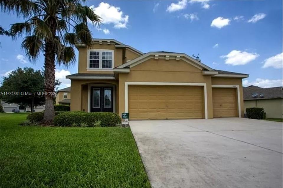 a front view of a house with a garden and garage