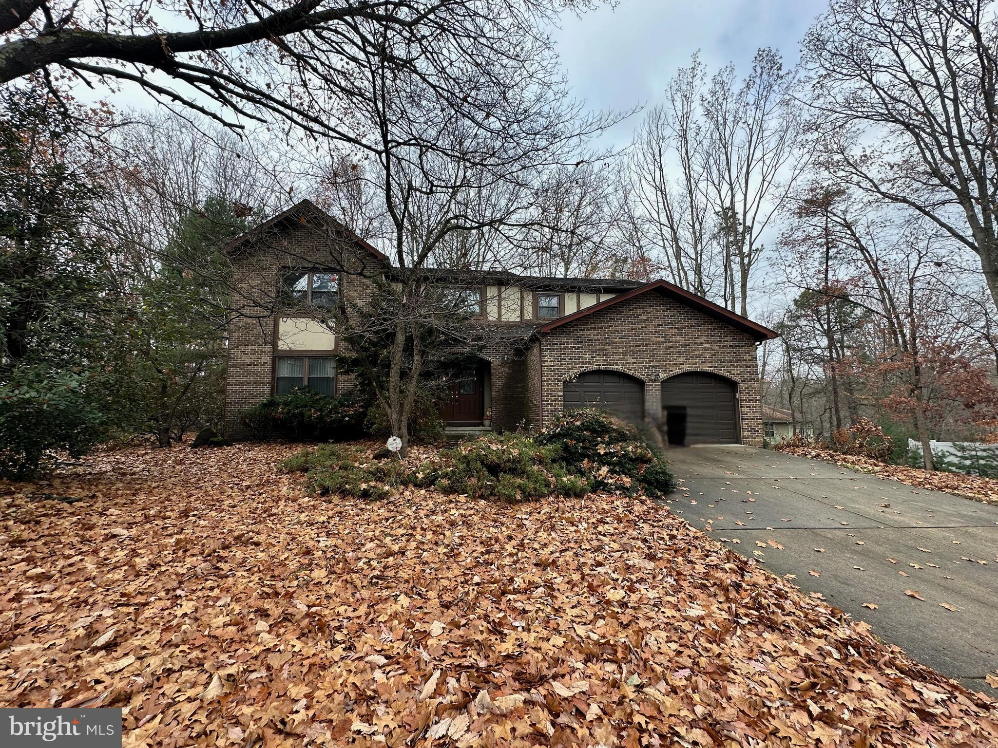 a front view of house with yard and trees around