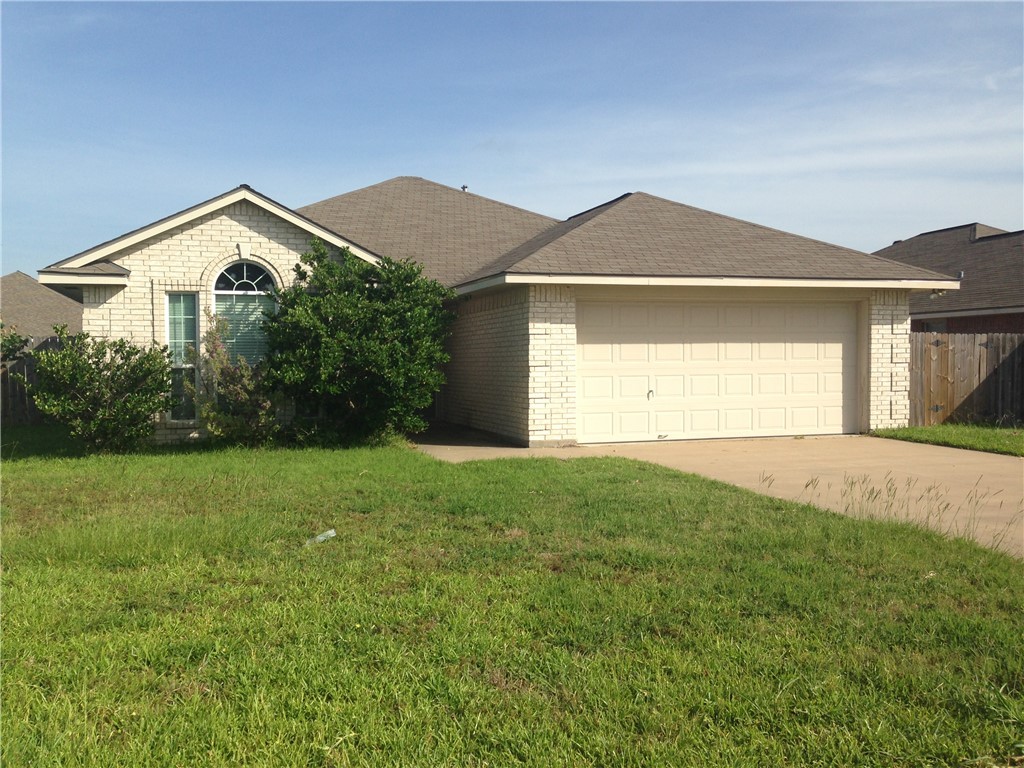 Ranch-style house featuring a front yard and a gar