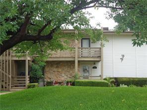 a view of a yard in front of a house with a large tree