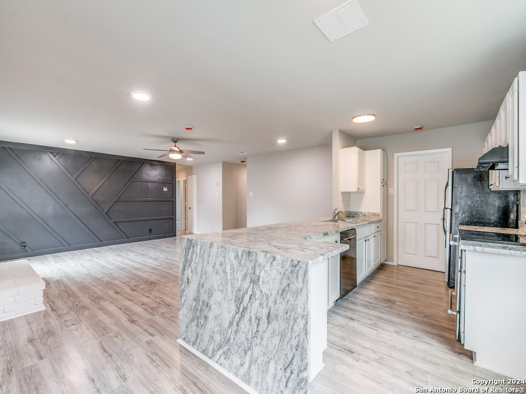 a large kitchen with kitchen island a sink stainless steel appliances and cabinets