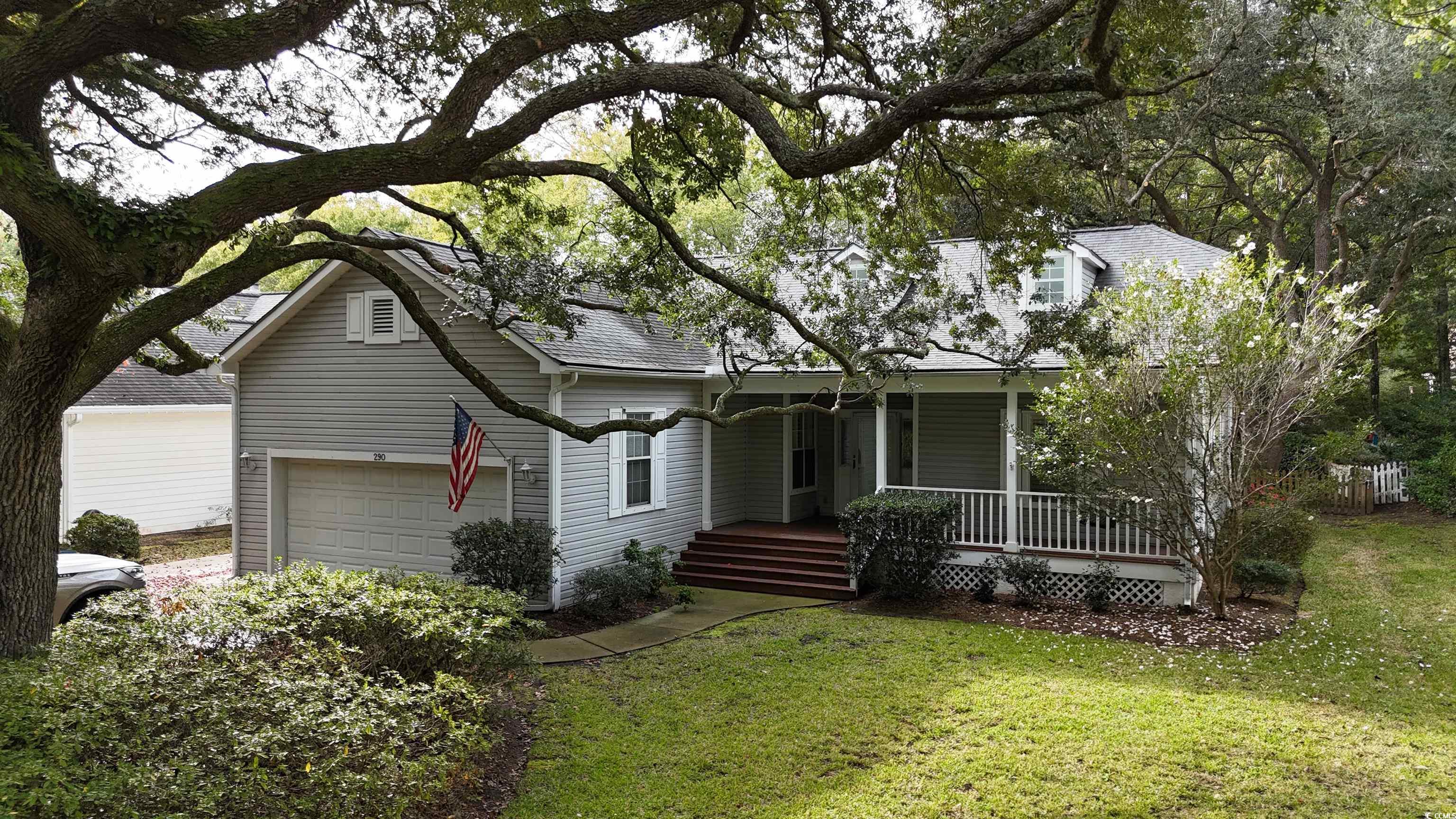 View of front facade featuring a garage, a front y