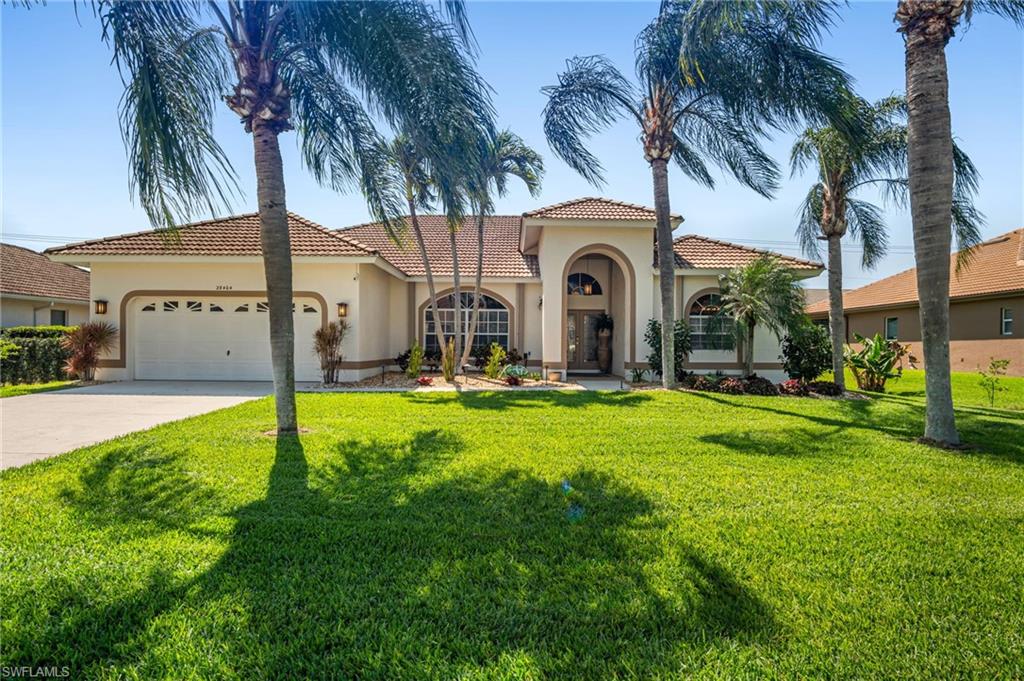 Mediterranean / spanish-style home with a garage and a front yard