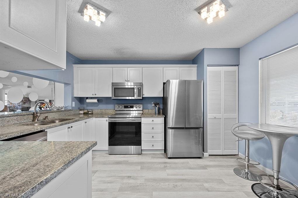 a kitchen with stainless steel appliances granite countertop a refrigerator sink and stove