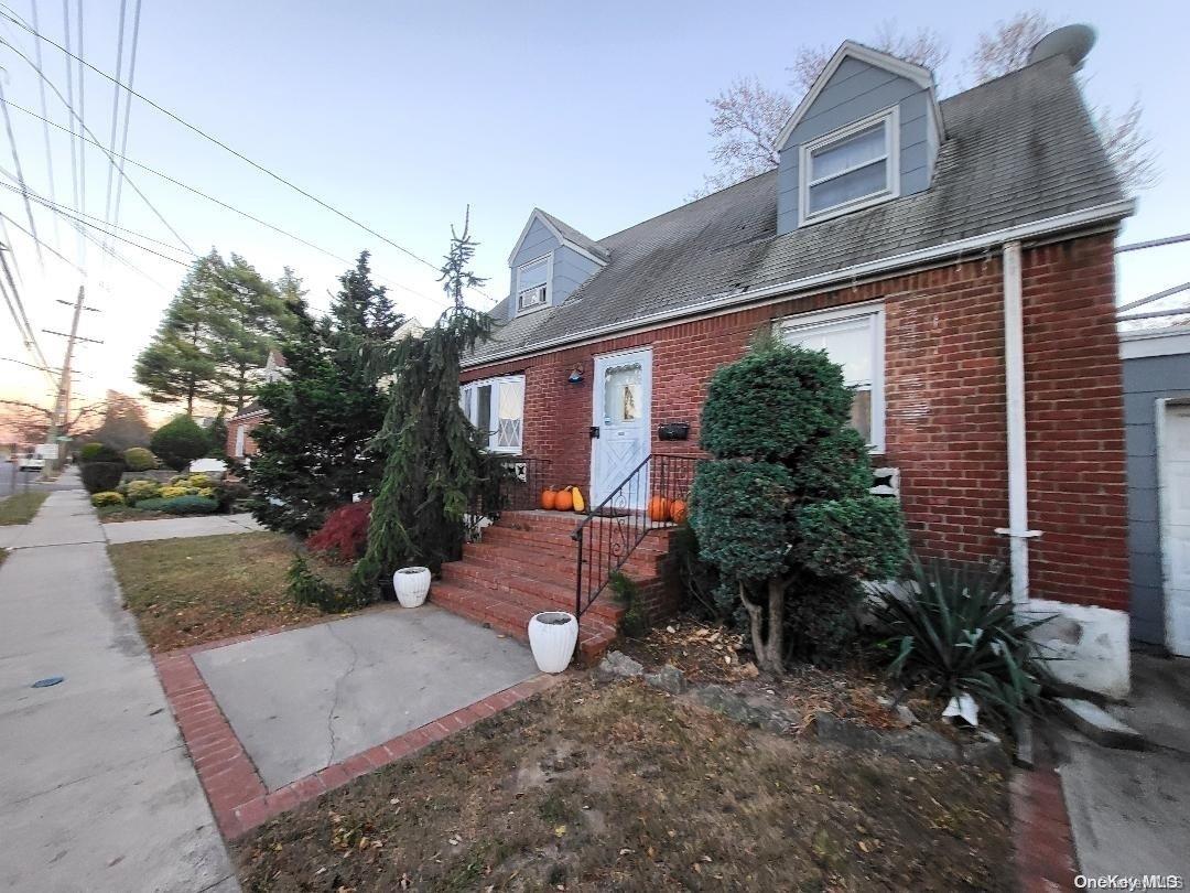 a view of a house with a yard and potted plants