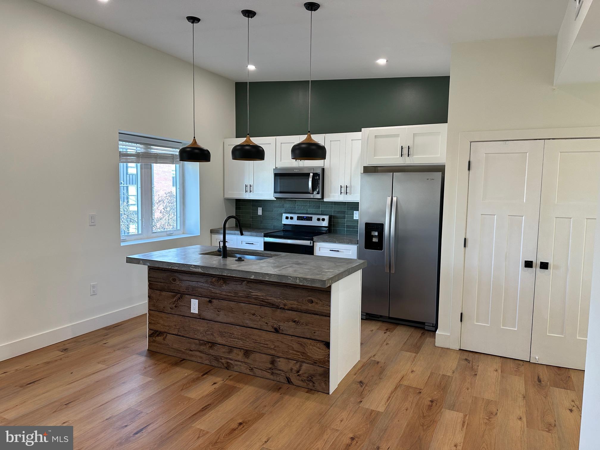 a kitchen with stainless steel appliances a refrigerator and a stove top oven