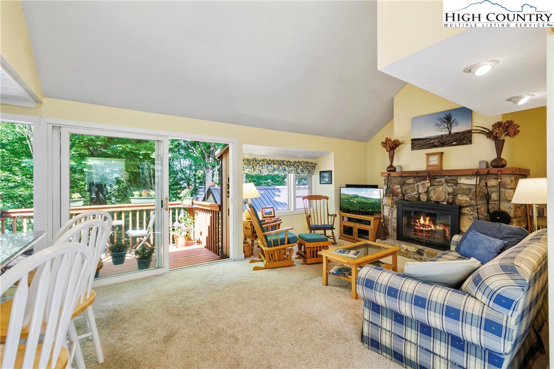 a living room with furniture a fireplace and a floor to ceiling window