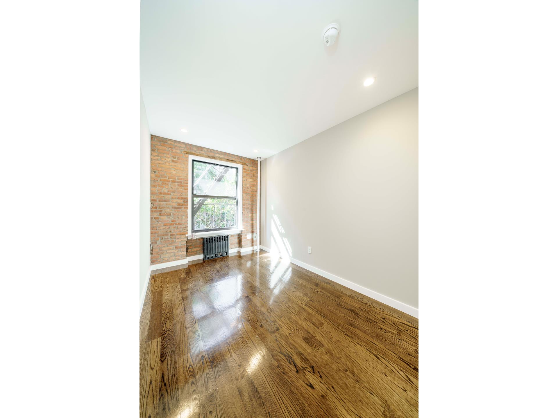 a view of a room with wooden floor and furniture