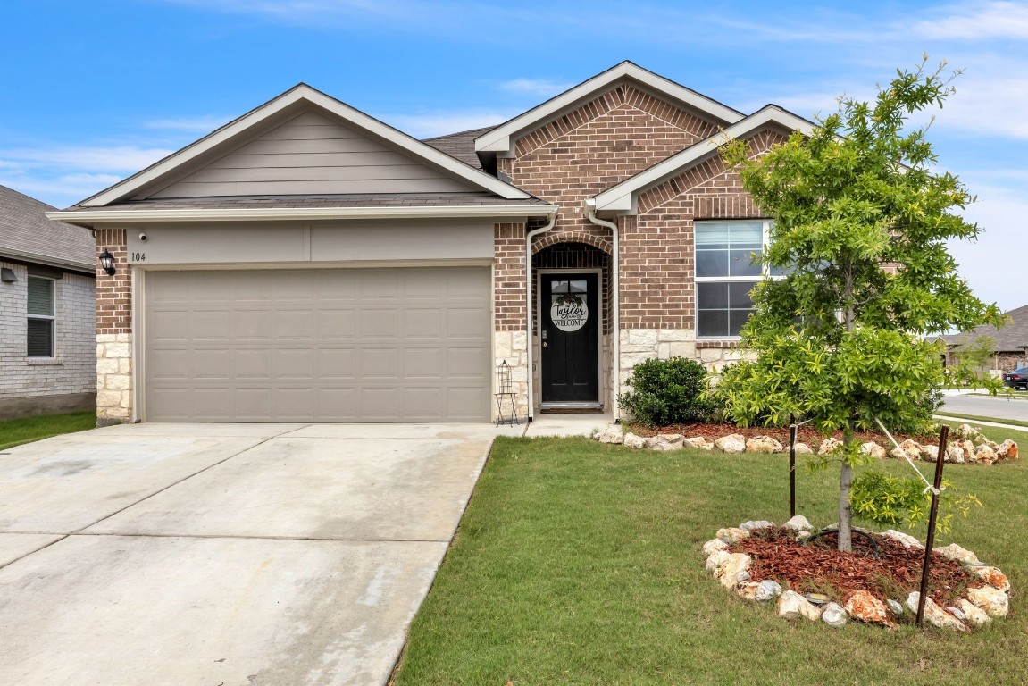 a front view of a house with a yard and garage