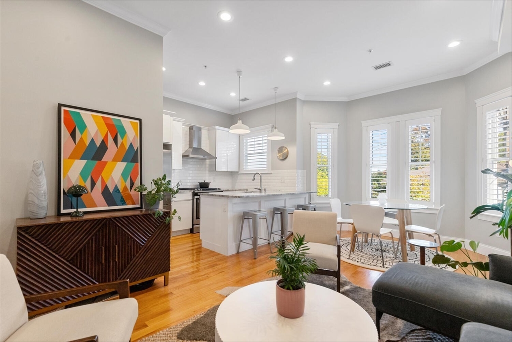 a living room with furniture kitchen view and large windows