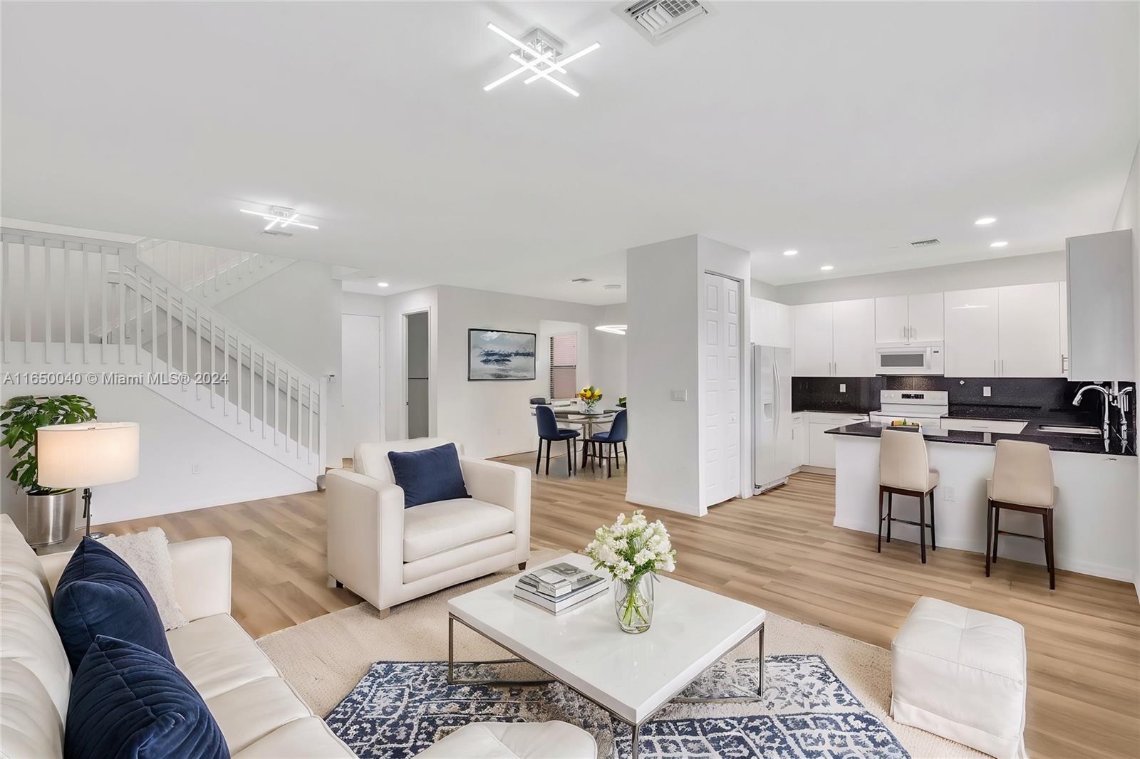 a living room with furniture and kitchen view