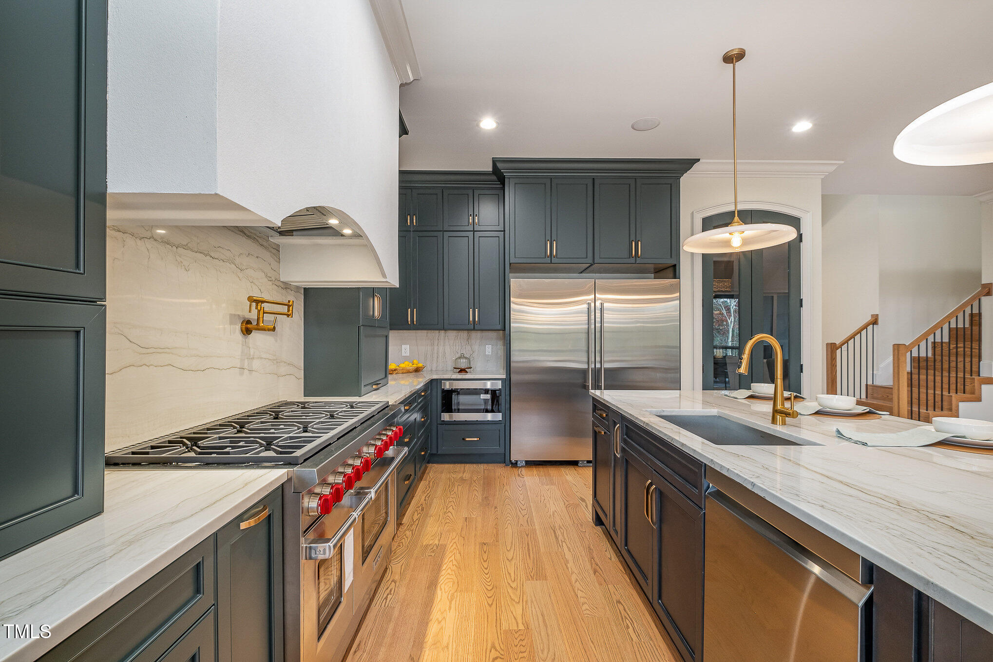 a kitchen with stainless steel appliances granite countertop a sink stove and refrigerator