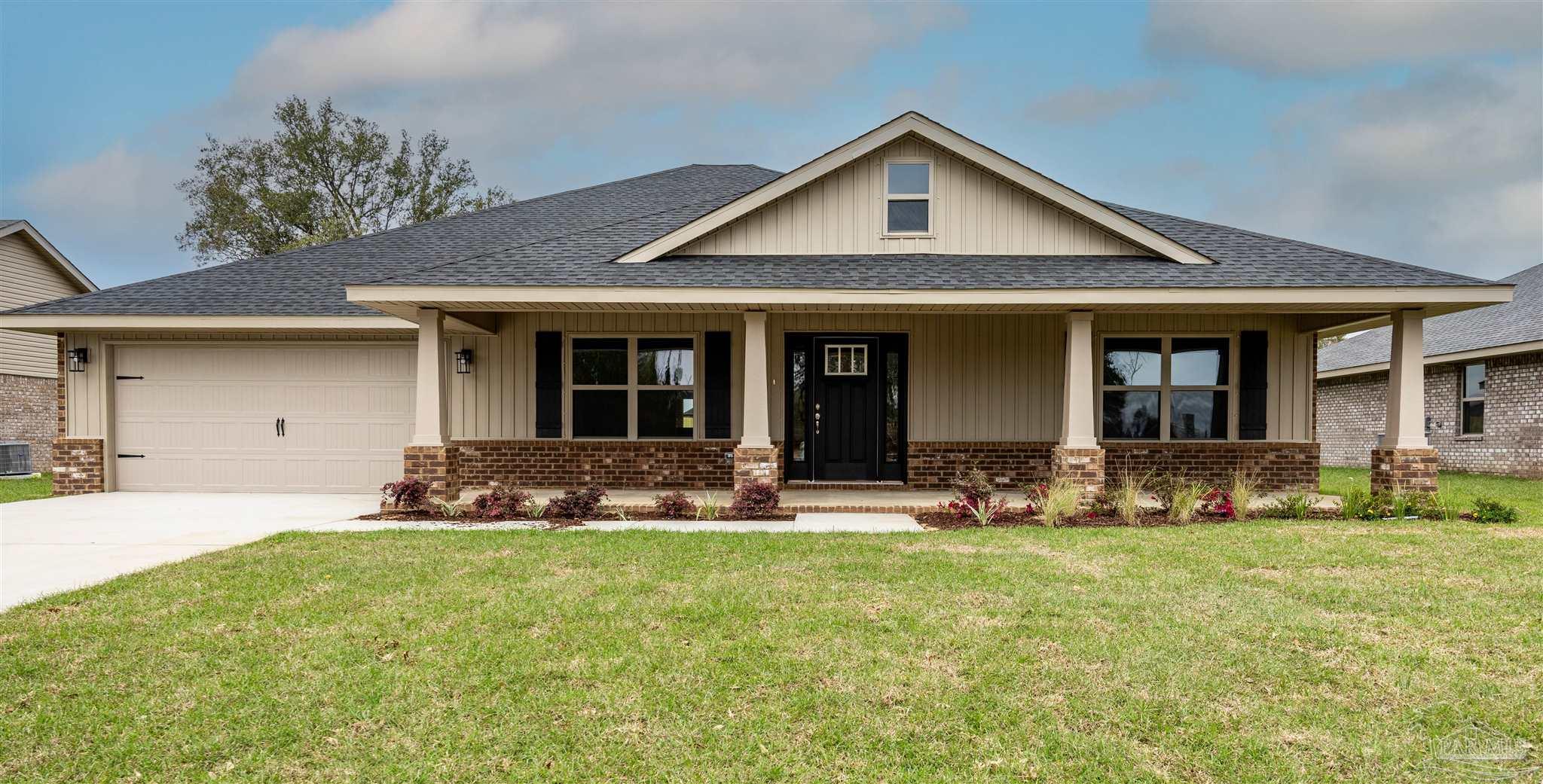 a front view of a house with yard and green space