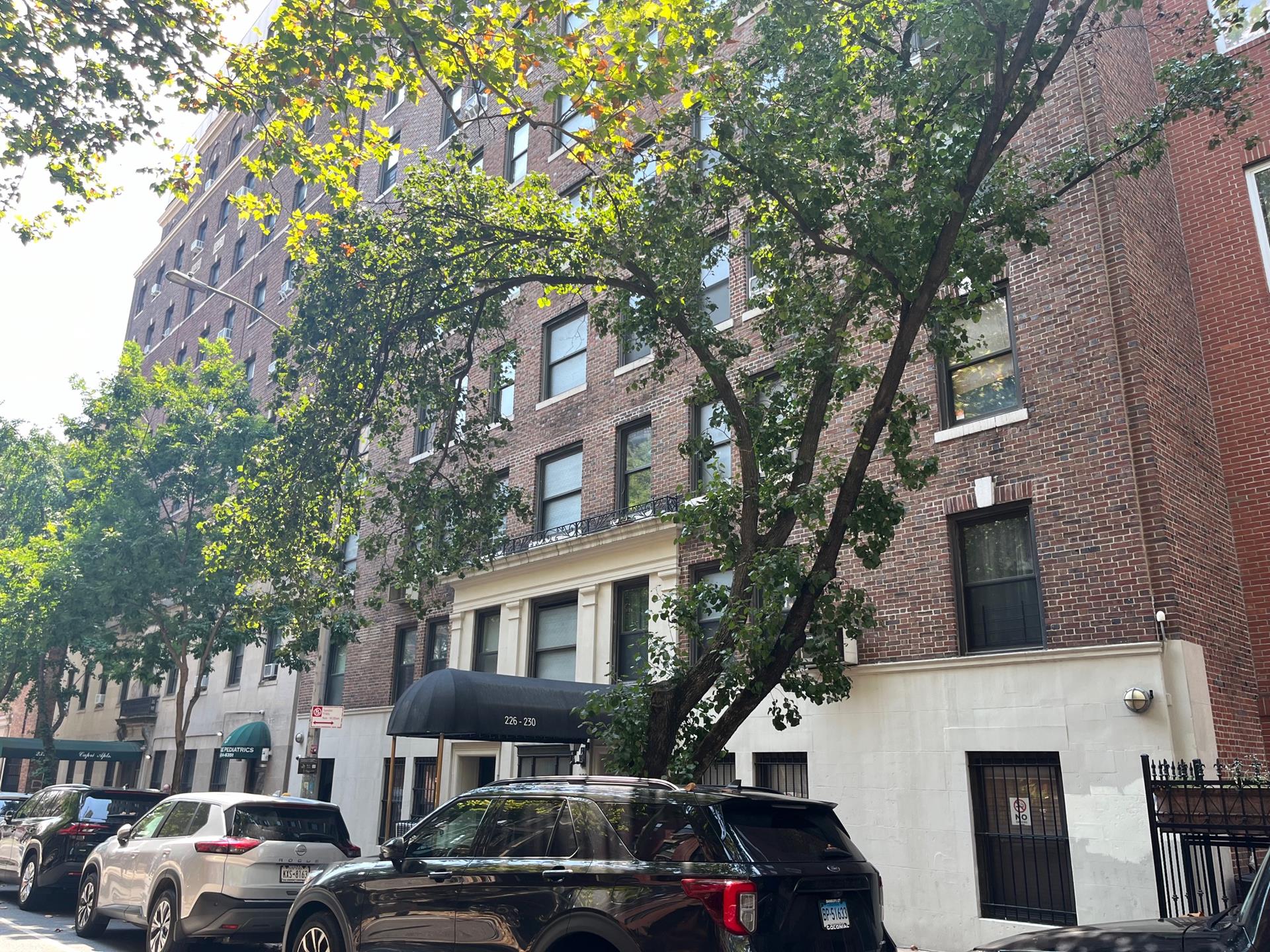 a front view of a building with trees