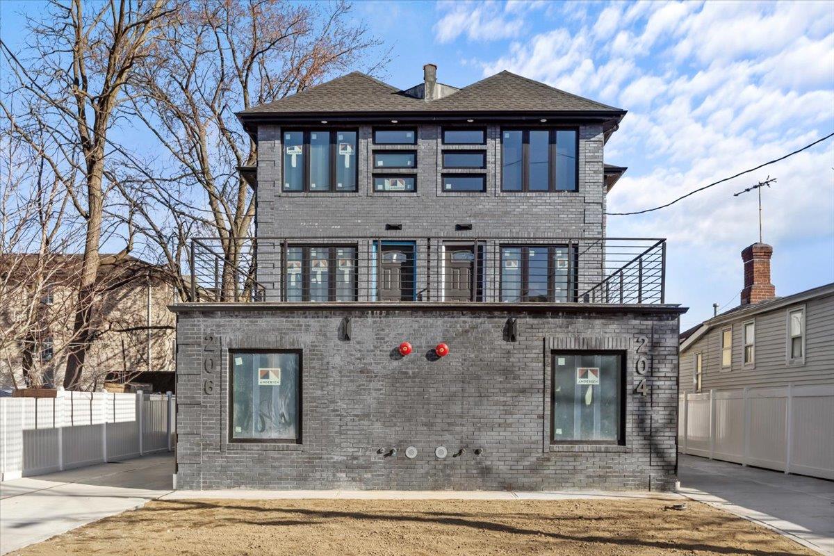 View of front of property with a patio and a balcony