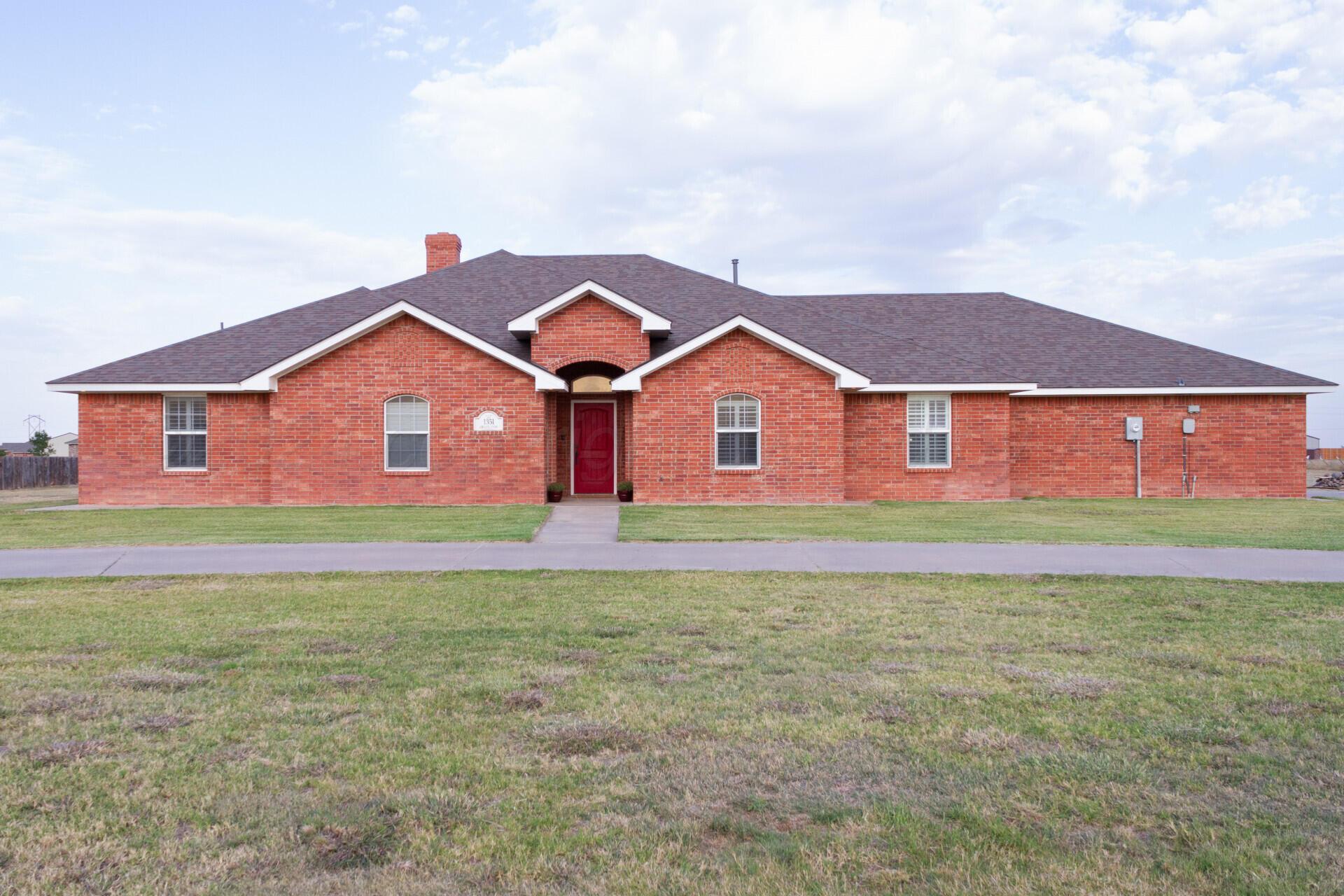 a front view of a house with a garden and yard