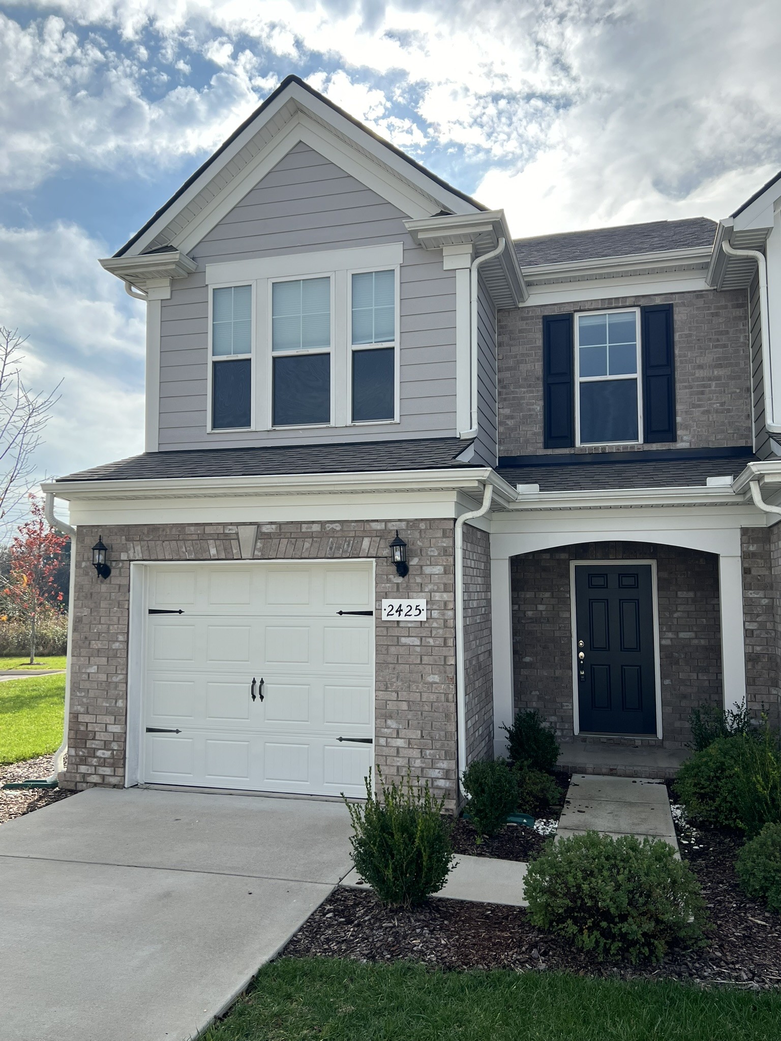 a front view of a house with a yard and garage