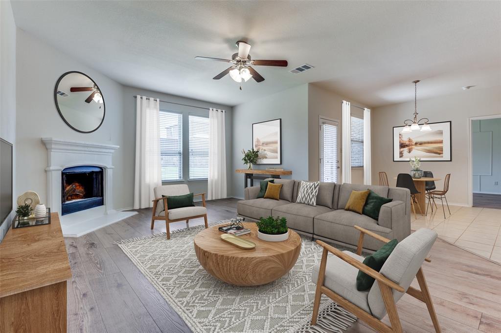 a living room with furniture a large window and a fireplace