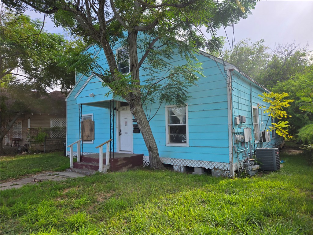 a view of a house with backyard and a tree