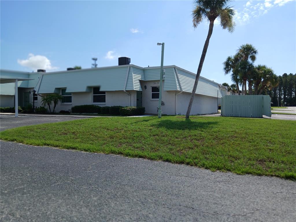 a view of a house with a yard and palm trees