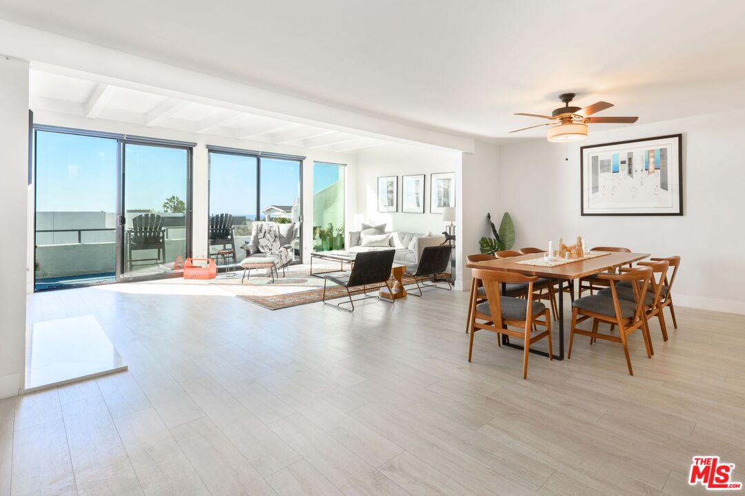 a dining room with furniture a chandelier and wooden floor