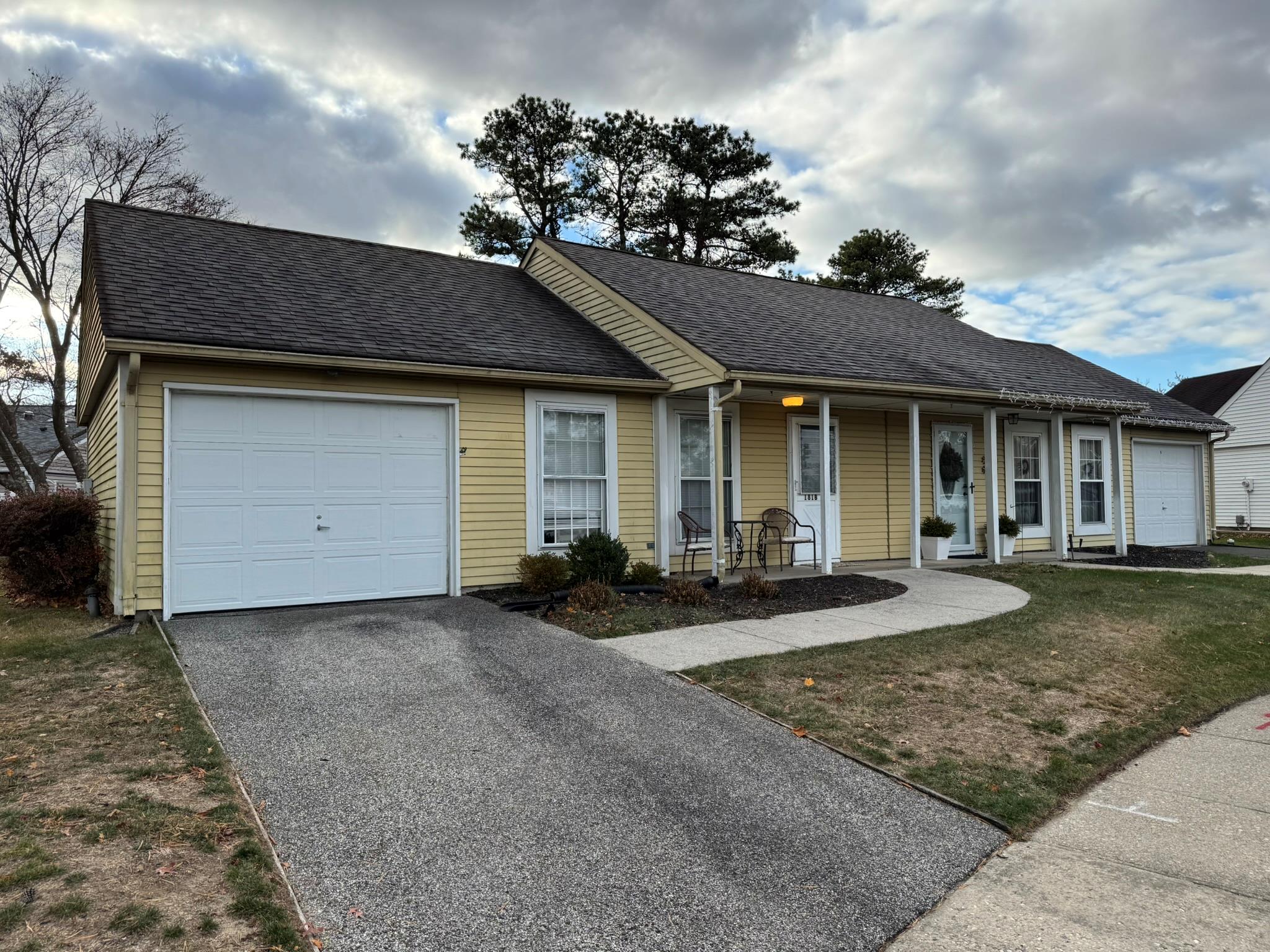 Single story home with a front lawn, a porch, and a garage