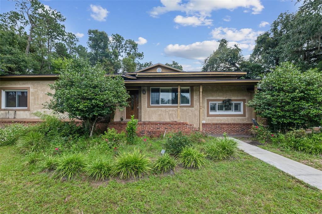 a front view of a house with yard and green space