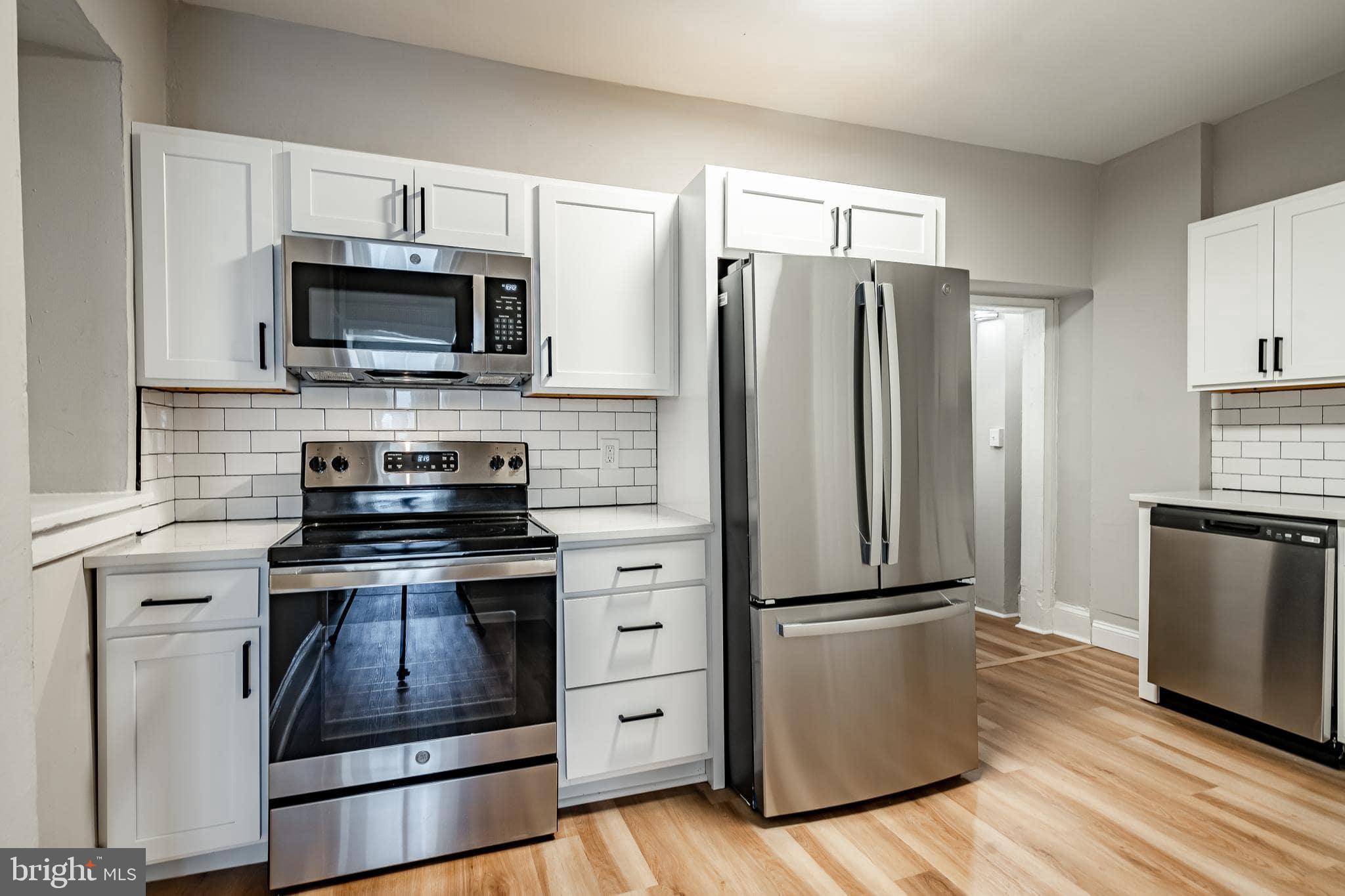 a kitchen with stainless steel appliances a refrigerator stove and microwave