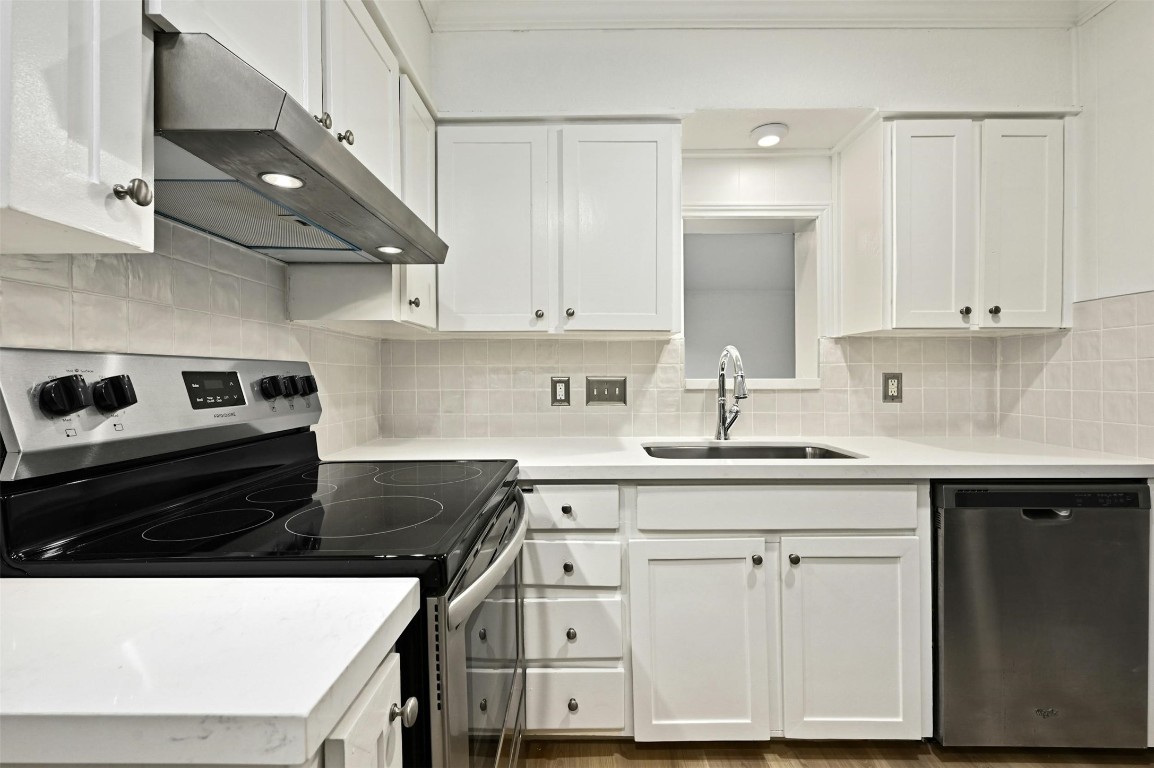 a kitchen with cabinets appliances and a sink