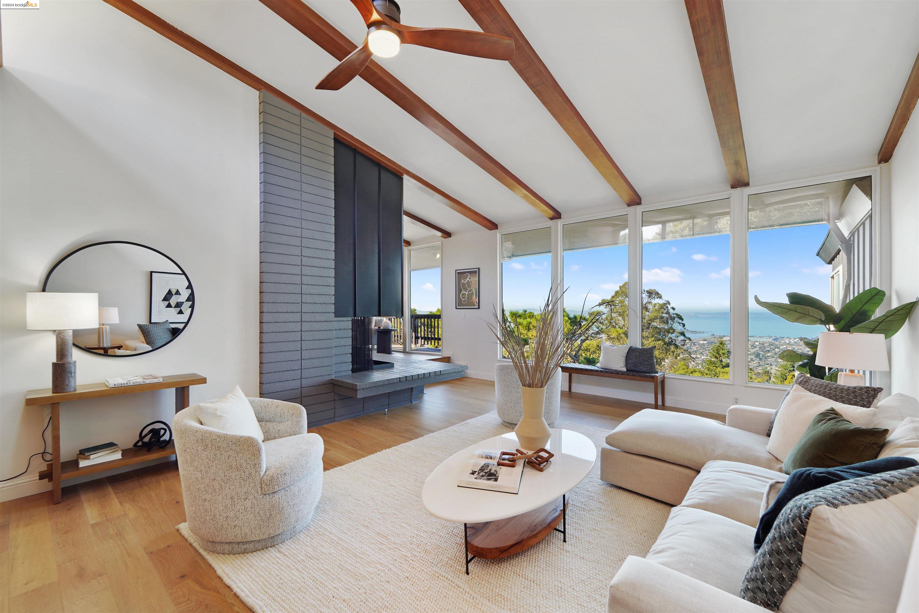 a living room with furniture a rug kitchen view and a large window