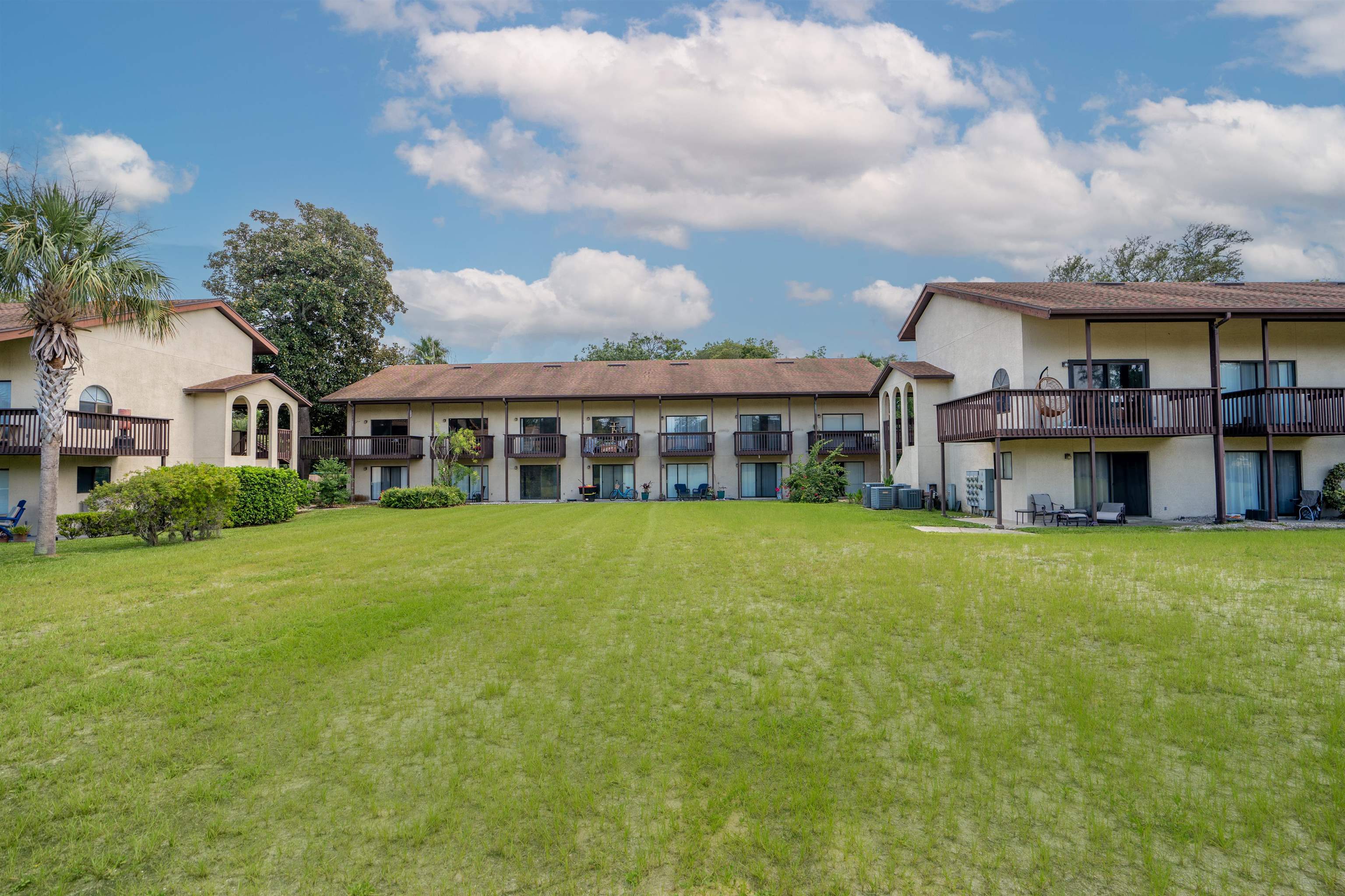 a view of a big house with a big yard and large trees