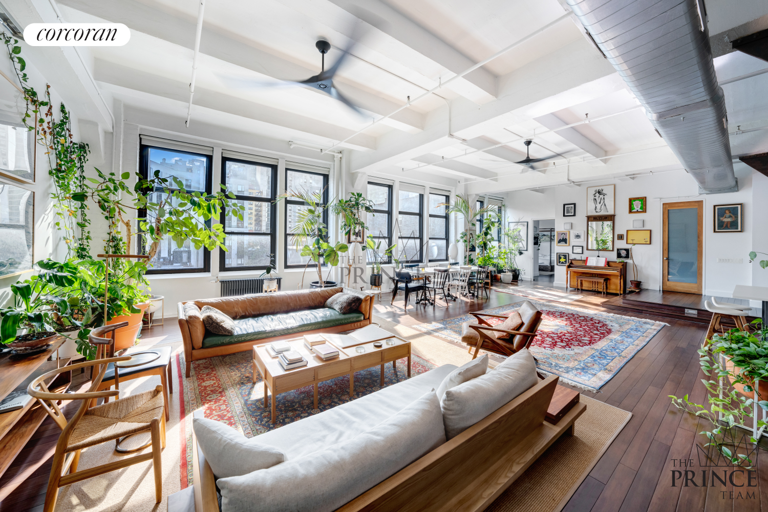 a living room with lots of furniture and a potted plant