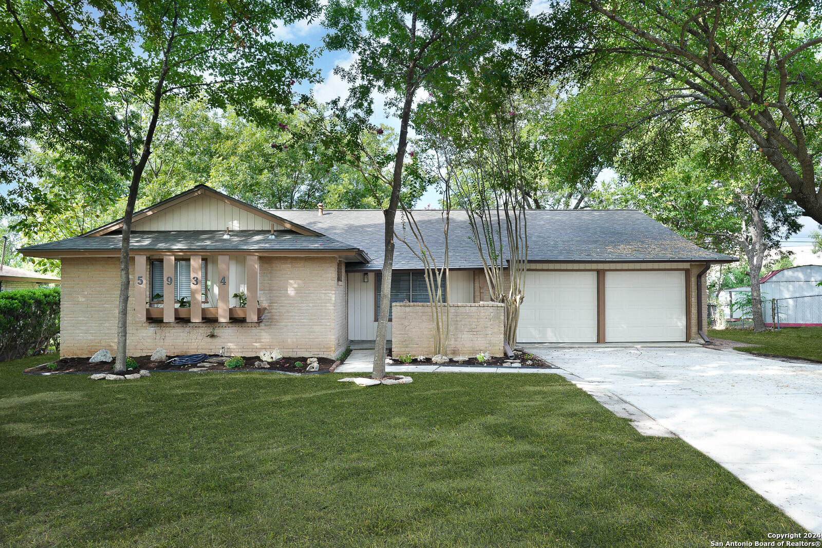 a front view of a house with a garden and yard