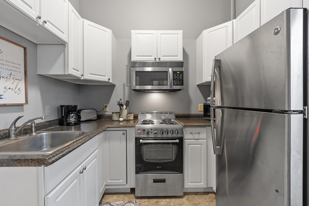 a kitchen with stainless steel appliances granite countertop a refrigerator stove and sink