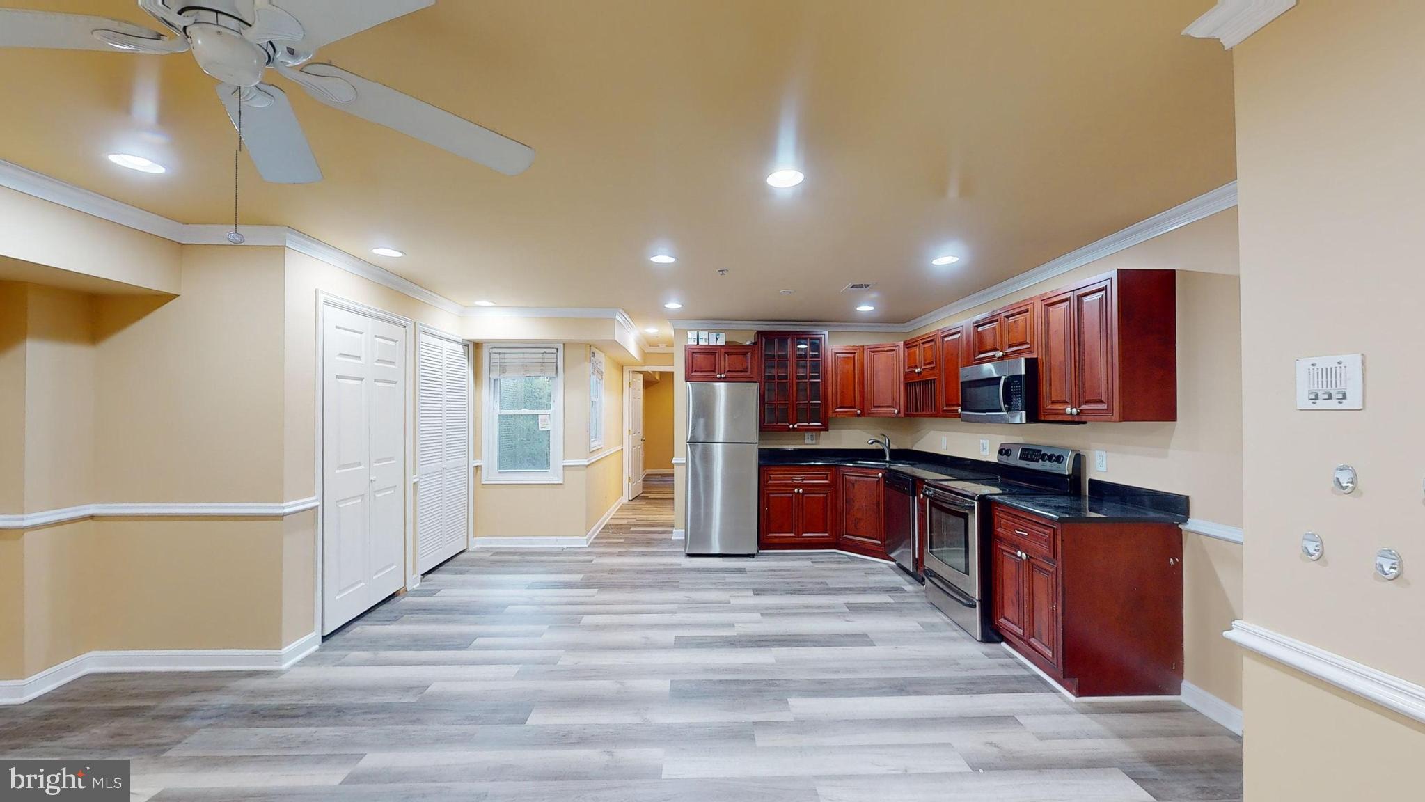 a large kitchen with stainless steel appliances granite countertop a refrigerator and a stove