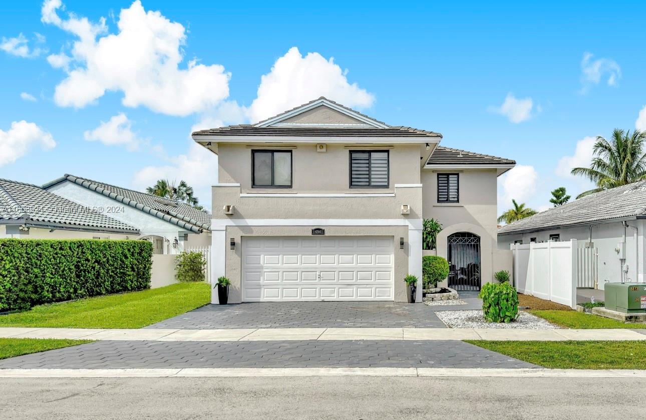 a front view of a house with a yard and garage