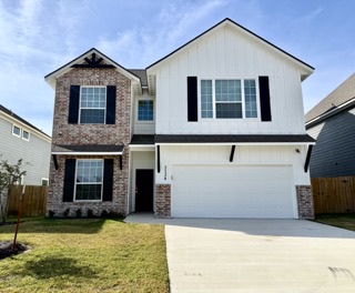 a front view of a house with yard and garage