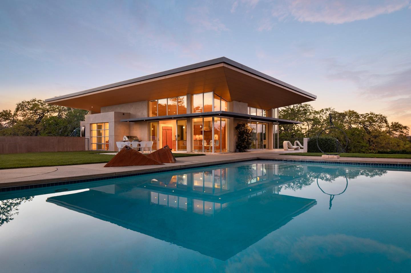 a front view of a house with swimming pool and yard