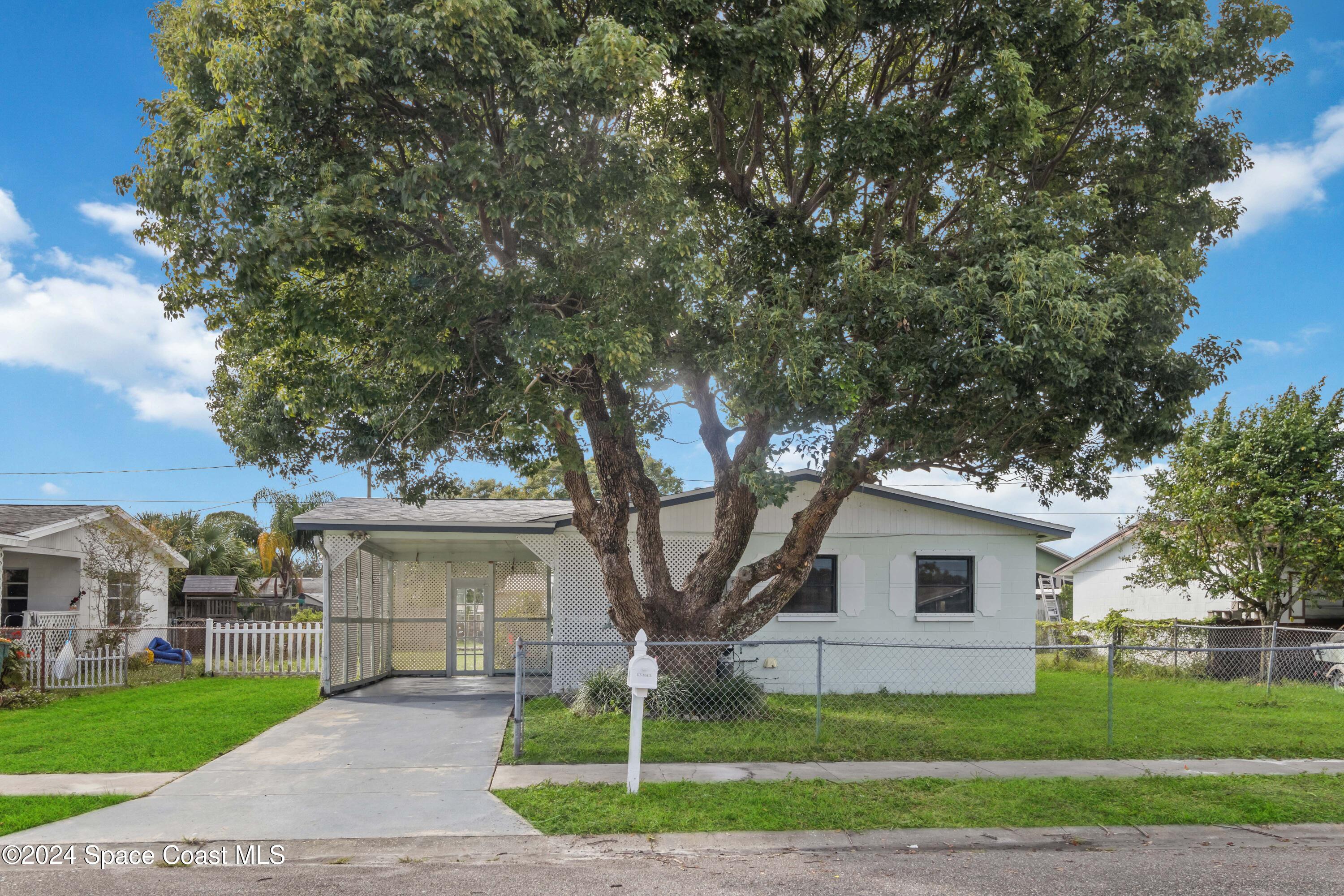 a white house that has a tree in front of it