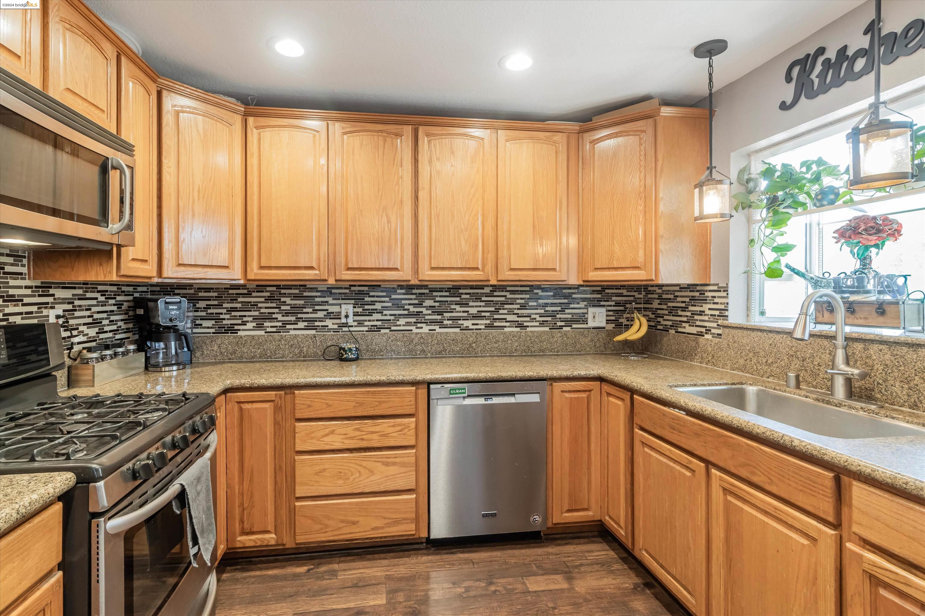 a kitchen with stainless steel appliances granite countertop a sink stove and cabinets