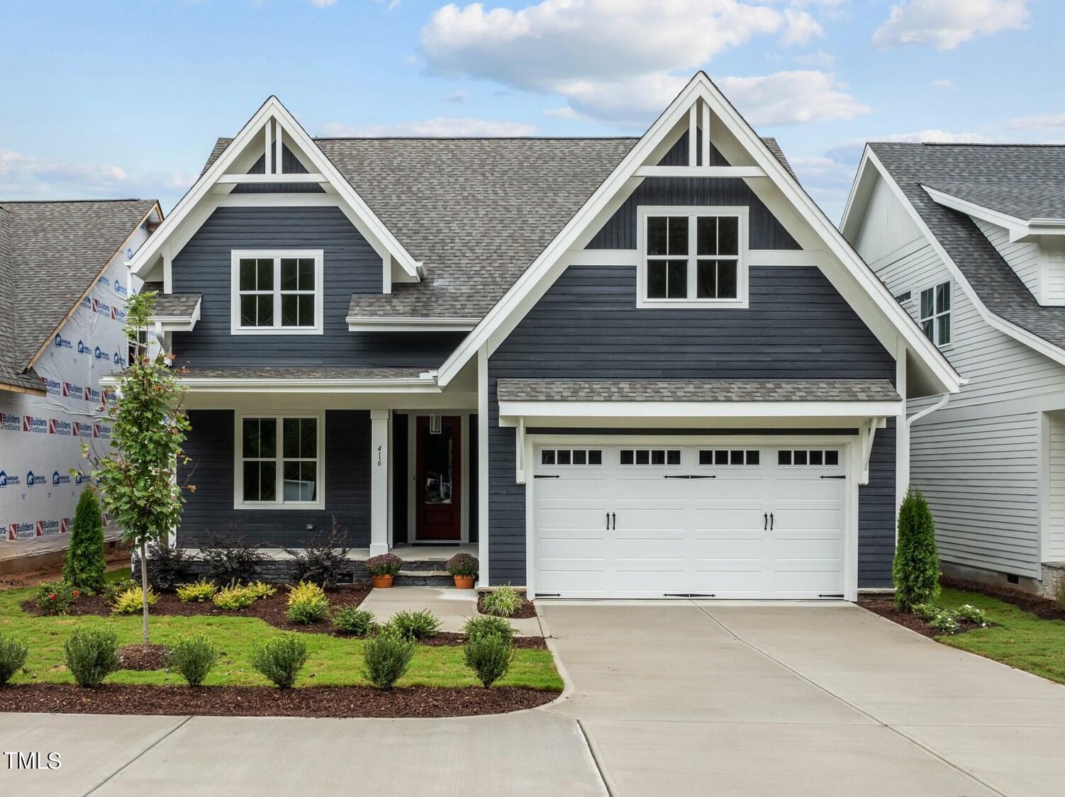 a front view of a house with a yard garage and outdoor seating