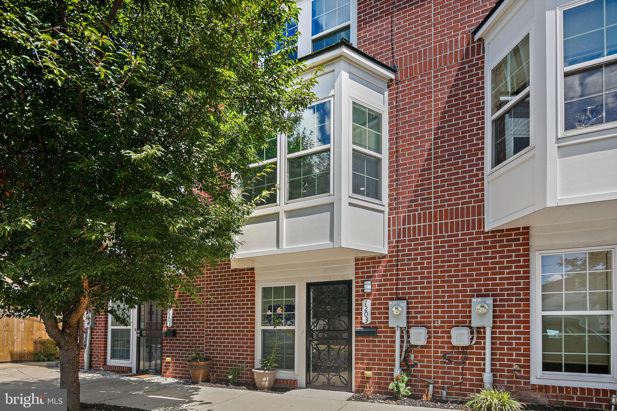 a front view of a building with a tree