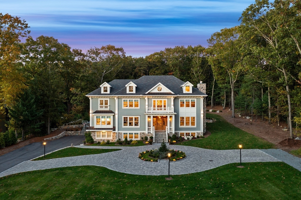 a view of a big house with a big yard plants and large trees