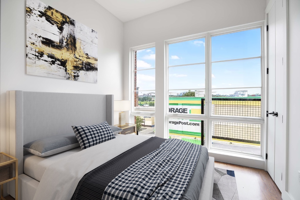 a bedroom with a bed cabinets and a window