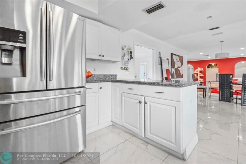 a kitchen with white cabinets and sink