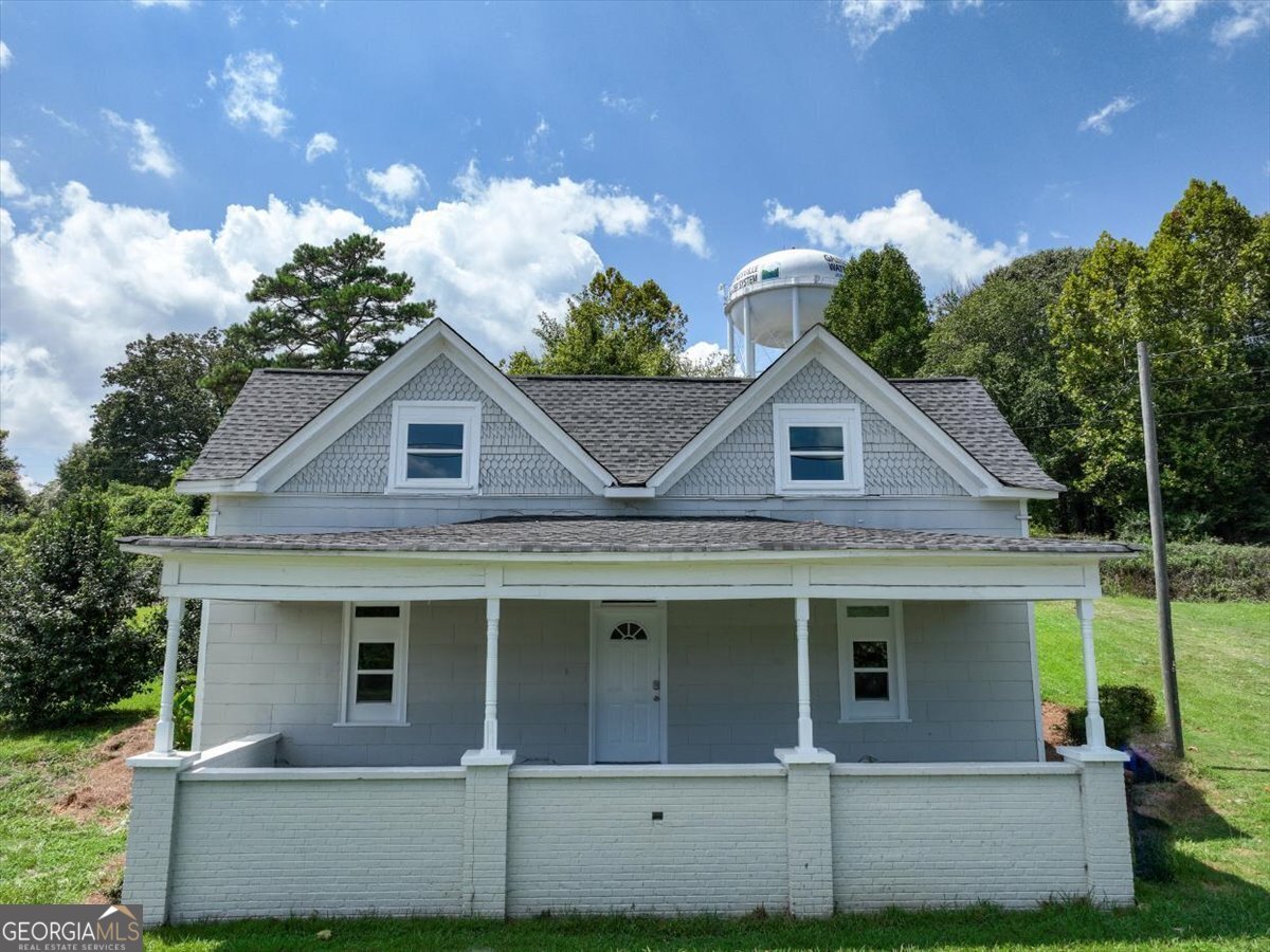 a view of a white house with large windows and a yard